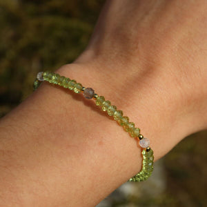 Hand wearing handmade faceted Peridot and Labradorite gemstone bracelet, 17cm in length, sparkling in natural light.