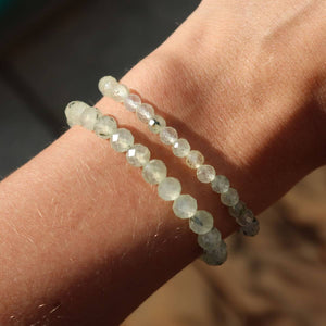 Faceted Prehnite gemstone bracelet on wrist in natural light, showcasing its delicate green hues and elegant design.