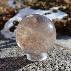 Rauchquarz Kugel – Natürliche Kristallkugel 60mm Durchmesser Nr. 45, reflektiert Licht auf Stein, zeigt ihre rauchige braune Tönung.