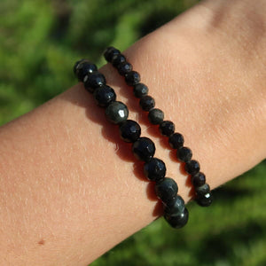Faceted Rainbow Obsidian gemstone bracelets in 4-6-8mm sizes on wrist, sparkling vividly in sunlight.