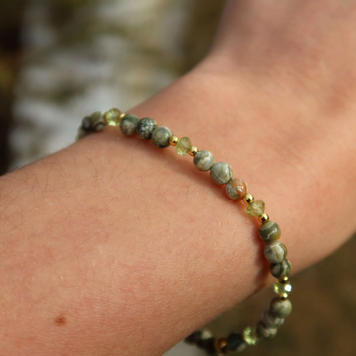 Handcrafted Rhyolith Rainforest Stone and Peridot gemstone bracelet, 17cm, showcasing faceted beads on wrist.