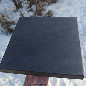 Große Schungit Platte Poliert - XL - 20x20x2cm - Polierter EMF auf Schnee hinter Hintergrund