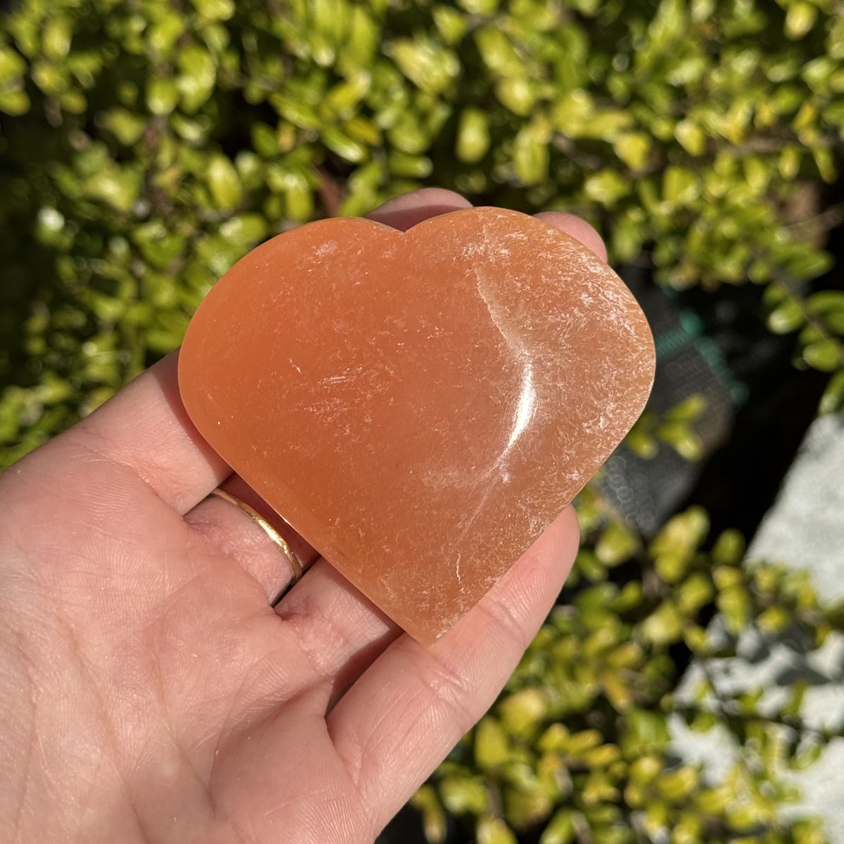 Selenit Herz Orange - Handschmeichler - 6cm - Schutzstein für Stabilität und Nervenstärkung in Hand gehalten.