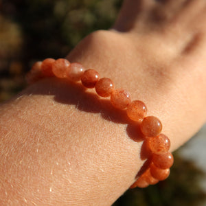 Sonnenstein Edelstein Armband - 1 Stück - in Varianten 4-5-6 oder 8mm, dargestellt auf einem Handgelenk, funkelnde Regenbogenfarben