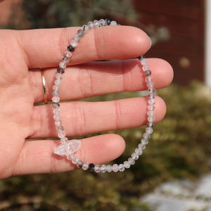 Hand holding handmade Turmalinquarz and Herkimer diamond faceted gemstone bracelet, 17cm, with protective black tourmaline beads.