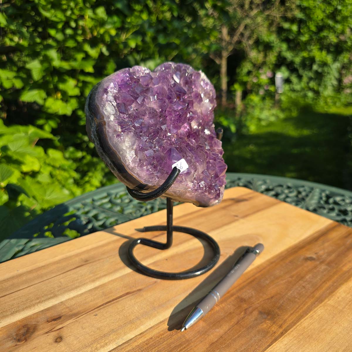 Amethyst Druse Amethyst Geode in Herzform mit Metallsockel 19x16x11cm - NR-36 auf einer Holzoberfläche.