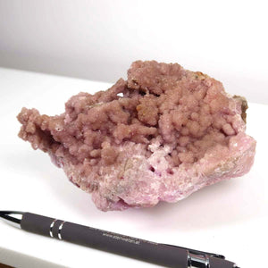 Kobalt Calcit mineral, natural pink crystal raw stone from Morocco, unique piece, displayed beside a pen for scale.