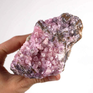 Natural pink Cobaltocalcite mineral raw stone held in hand, displaying vibrant crystal structure. Unique Moroccan mineral specimen.