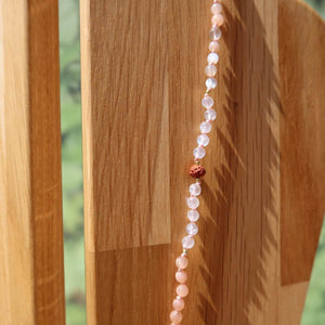 Mondstein mit weißem Labradorit und Rudraksha Kette auf Holz, harmonisches Schmuckstück für Intuition und Kraft.