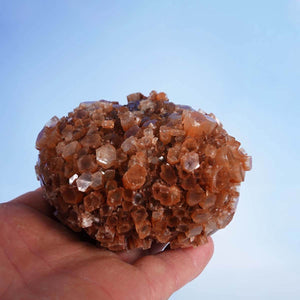 Hand holding raw Aragonite crystal cluster from Morocco, showcasing complex natural formations, ideal for collectors or mineral enthusiasts.