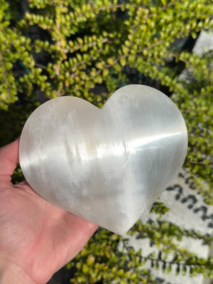 Selenit Herz XL (13-14cm) - Schutzstein für Stabilität und Nervenstärkung in einer Hand gehalten.