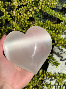 Selenit Herz - Handschmeichler - 10cm - Schutzstein für Stabilität und Nervenstärkung in Hand gehalten.