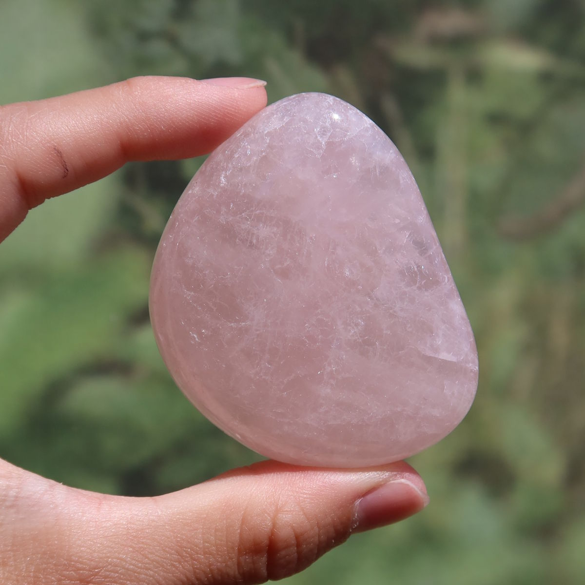 Rosenquarz Handschmeichler - Selbstliebe und Harmonie - Nr. 17 in zartem Rosaton, in der Hand gehalten.