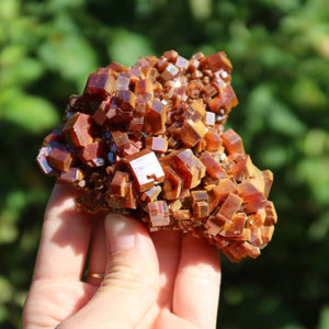 Vanadinit - Natürliche Kristallstufe aus Marokko 8x6x3cm - 0,27kg Nr.44 in Hand gehalten, leuchtende rot-orangefarbene Kristalle.