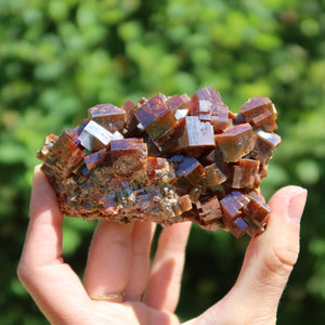 Vanadinit - Natürliche Kristallstufe aus Marokko 9x5x3,5cm - 0,36kg Nr.1 in Hand mit grünem Hintergrund.